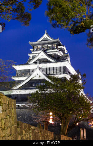 Schloss Kumamoto in Japan. Nachtsicht, mit Schloss, genannt die Daitenshu, mehr halten, beleuchtet. Bäume im Vordergrund. Stockfoto