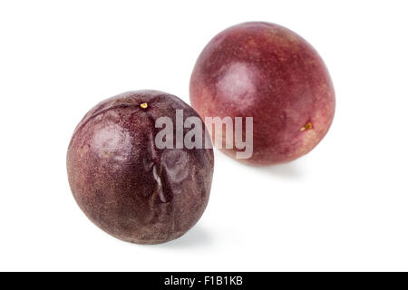Nahaufnahme von zwei ganze Maracujas (Passionsfrüchte, lila Granadilla (Passiflora Edulis)) isoliert auf weißem Hintergrund. Stockfoto
