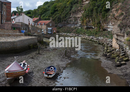 Angelboote/Fischerboote an der Gezeiten-Mündung des Staithes Beck als es betritt Staithes Hafen, Staithes, North Yorkshire, UK. Stockfoto