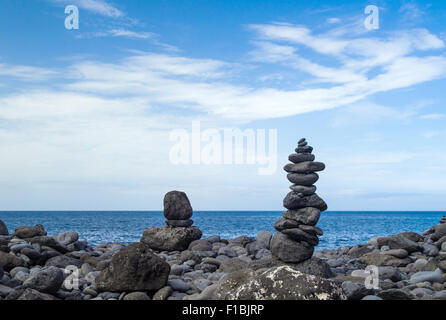 Cairns am schwarzen vulkanischen Kiesstrand Stockfoto