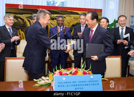 (150901)--Peking, 1. September 2015 (Xinhua)--Xinhua Präsident Cai Mingzhao (R vorne) schüttelt Hände mit Peter Maurer, Präsident des internationalen Komitees des Roten Kreuz (IKRK), nach der Unterzeichnung ein Memorandum of understanding (MoU) über die strategische Zusammenarbeit in Peking, Hauptstadt von China, 1. September 2015. Laut dem Dokument werden die beiden Organisationen ihre Zusammenarbeit in den Bereichen Media Services, Training und humanitäre Angelegenheiten Rindfleisch. (Xinhua/Huang Jingwen) (Mt) Stockfoto