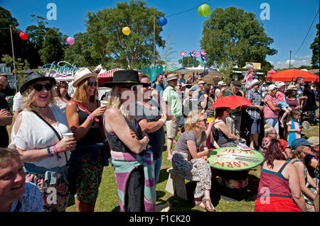 Familien beobachten einen akrobatischen Akt in der Sommersonne von Garküchen und Zelten am Hafen Eliot Festival Cornwall Stockfoto