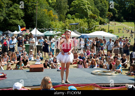 Familien beobachten einen akrobatischen Akt in der Sommersonne von Garküchen und Zelten am Hafen Eliot Festival Cornwall Stockfoto