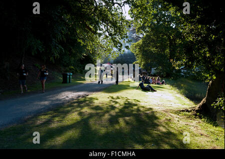 Festivalbesucher zu sitzen, entspannen und trinken im Schatten am Flussufer der Mündung am Hafen Eliot Festival Cornwall Stockfoto