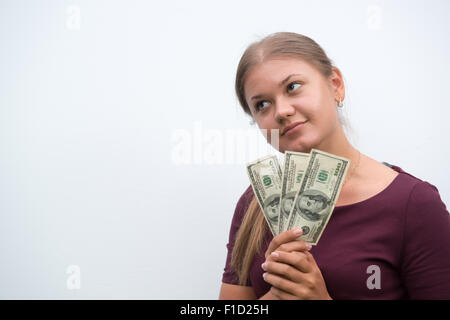 Junge Frau Bargeldhaltung Dollar in der hand und zum Nachdenken über Geld auf dem weißen Hintergrund Stockfoto