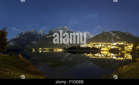 Nacht-Landschaft auf dem Moveno See und Stadt mit Dolomiti Brenta-Gruppe im Hintergrund bei Mondschein Stockfoto