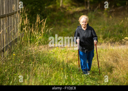 Reife Frau in Nordic walking außerhalb der Stadt beschäftigt. Stockfoto