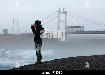 Eine weibliche Touristen fotografieren von Eisbergen in Jökulsárlón Eis Lagune Stockfoto