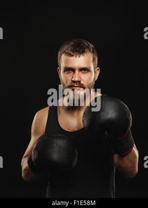 Athletische bärtigen Boxer mit Handschuhen auf dunklem Hintergrund Stockfoto