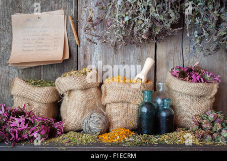 Heilkräuter in Hessischen Taschen in der Nähe von Holzwand, Kräutermedizin. Stockfoto