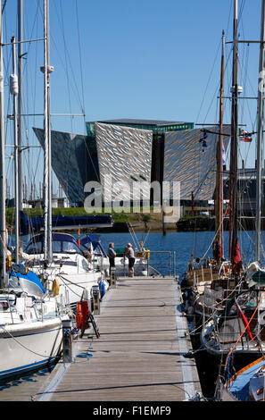 Belfast Hafen Marina, Nordirland - zwei Männer im Chat neben Boote mit Titanic Belfast Centre im Hintergrund Stockfoto