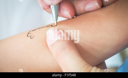 Tattoo Kinder zeichnen. Animator zieht Prinzessin auf dem Arm eines kleinen Mädchens Stockfoto