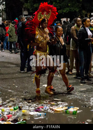 London, UK. 31. August 2015. Eine Darsteller in einem bunten Kostüm geht Vergangenheit eine Pfütze Wurf nach der Notting Hill Carnival 2015 voller. Bildnachweis: Pete Maclaine/Alamy Live-Nachrichten Stockfoto