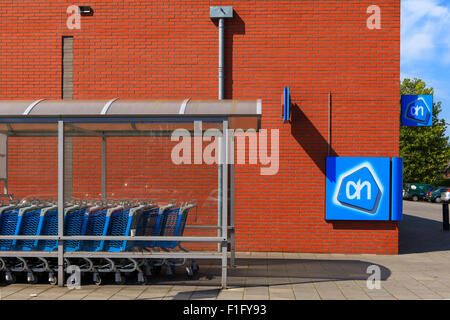 Supermarkt-Front mit blauen Einkaufswagen und roten Backsteinmauer Stockfoto