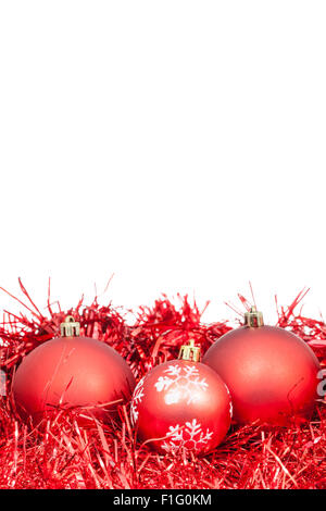 drei rote Christbaumkugeln und Lametta isoliert auf weißem Hintergrund Stockfoto