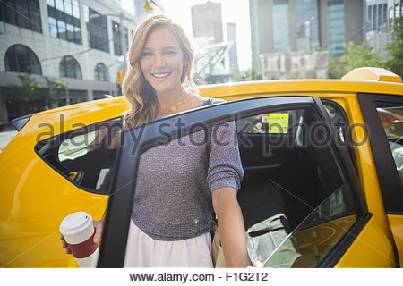 Porträt lächelnd Geschäftsfrau mit Kaffee immer aus dem taxi