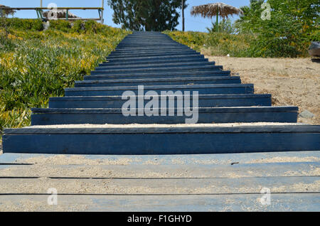 Strand von blauen Holztreppen mit Strandsand drauf Stockfoto