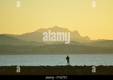 Einsamer Mann Angeln im Morgengrauen, Strand St. Aygulf, Frankreich Stockfoto