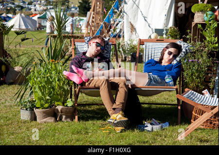 Junge und Mädchen schlafen auf Liegestühlen an einem Stand des Port Eliot Festivals Cornwall UK Stockfoto