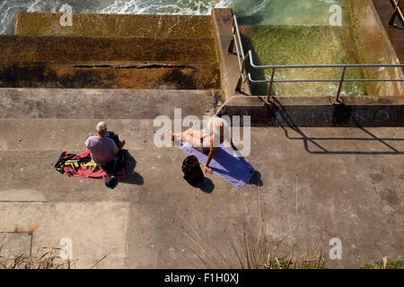 Zwei Männer auf einem Betonboden am Meer entspannen. Stockfoto