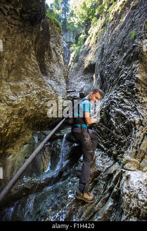 Teenager-Jungen Wanderer auf Sicherheit Ketten durch eine sehr enge Schlucht Klettern Stockfoto