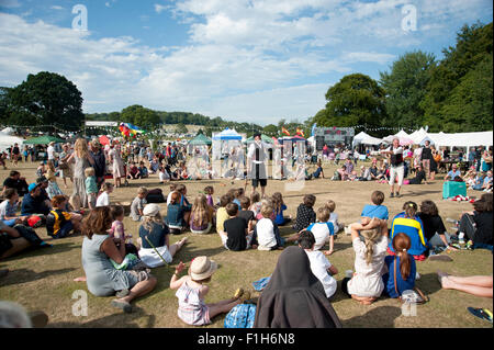 Familien beobachten ein Balanceakt in der Sommersonne von Garküchen und Zelten am Hafen Eliot Festival Cornwall Stockfoto