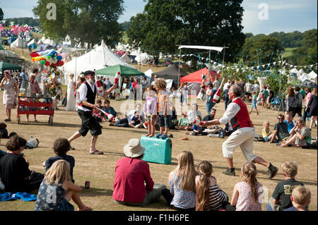 Familien beobachten ein Balanceakt in der Sommersonne von Garküchen und Zelten am Hafen Eliot Festival Cornwall Stockfoto