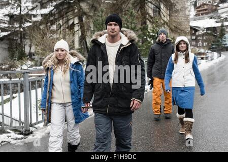Vier Freunde tragen Winterkleidung zu Fuß