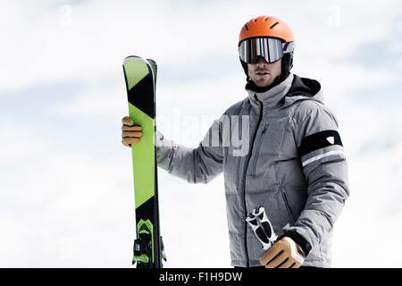 Mann mit Helm und Ski Brillen mit Skiern, Porträt Stockfoto