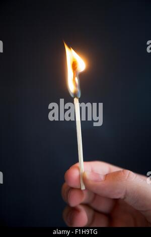 Person Holding brennendes Zündholz Stockfoto