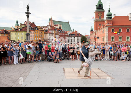 Oldie Breakdance show, Touristen, die gerade Straße Tanz-Performance in Old Town Square in Warschau, Polen. Altes Ehepaar in Masken. Stockfoto