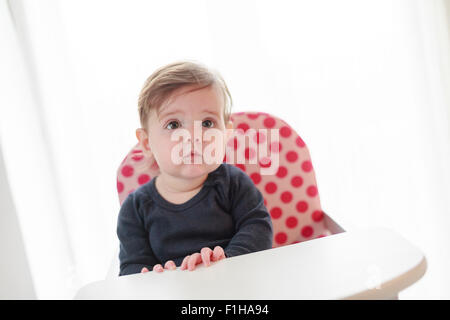Sechs 6 Monate altes Baby Mädchen im Hochstuhl Stockfoto