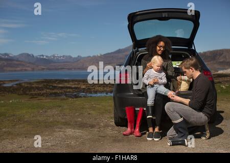 Eltern helfen Sohn Änderung Schuhe, Loch Eishort, Isle Of Skye, Hebriden, Schottland Stockfoto