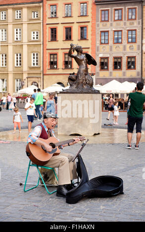 Alter Mann Sänger Gig spielt Gitarre in Old Town Market Place-Platz in Warschau, Polen. Streetart Busker Gesang Darstellers. Stockfoto