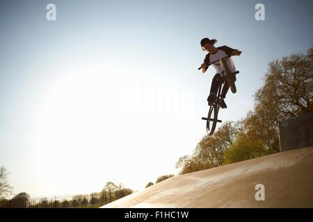 Junger Mann, in der Luft, Stunt auf bmx Skatepark zu tun Stockfoto