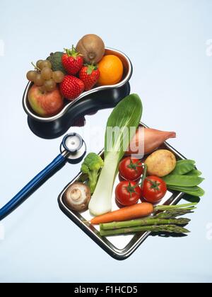 Stethoskop zwischen Schalen mit frischem Obst und Gemüse Stockfoto