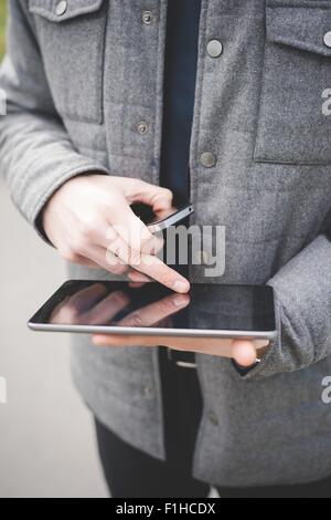 Bild von Händen der junge Geschäftsmann mit digitalen Tablet und Handy zugeschnitten. Stockfoto