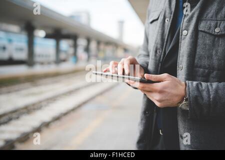 Zugeschnittenes Bild ein junger Geschäftsmann Pendler Hände mit digital-Tablette am Bahnhof. Stockfoto