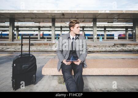 Porträt der jungen Geschäftsmann Pendler mit digital-Tablette am Bahnhof. Stockfoto