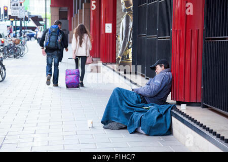 28. August 2015 - ein Obdachloser schläft auf der Straße außerhalb der British Library, London, UK Stockfoto