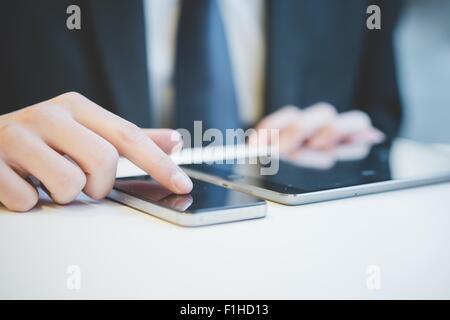 Bild von Händen der junge Geschäftsmann mit digitalen Tablet und Handy zugeschnitten. Stockfoto