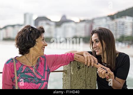 Reife Frau, die an Hand der Mutter am Strand Copacabana, Rio De Janeiro, Brasilien Stockfoto