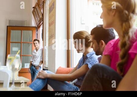 Junge Erwachsene Freunde betrachten über Teenager in Café Tür Stockfoto