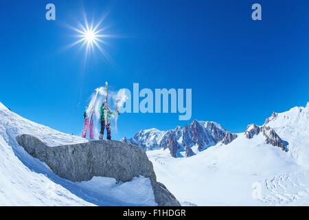 Männliche und weibliche Skifahrer schütteln Schnee Ski am Mont-Blanc-Massiv, Graian Alpen, Frankreich Stockfoto