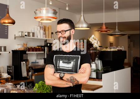 Porträt des Café Kellner mit verschränkten Armen Stockfoto