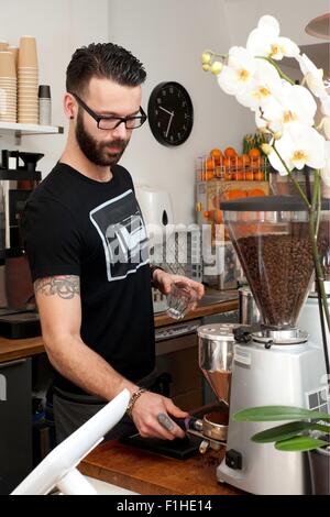 Cafe Kellner bereitet frischen Kaffee-Automaten hinter Theke Stockfoto