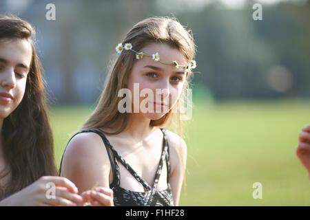 Porträt von Teenager-Mädchen tragen Daisy-Chain Kopfschmuck im park Stockfoto