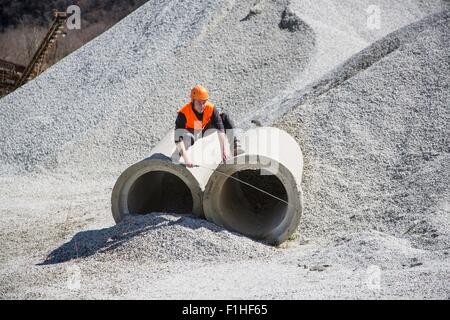 Steinbrucharbeiter Messung Industrierohre im Steinbruch Stockfoto