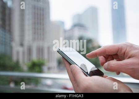 Mann mit Smartphone im Freien, Fokus auf Händen, Hong Kong, China Stockfoto