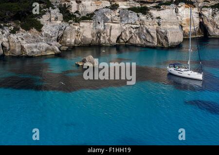 Klippen von Cala Macarella und Segelboot, Menorca, Spanien Stockfoto